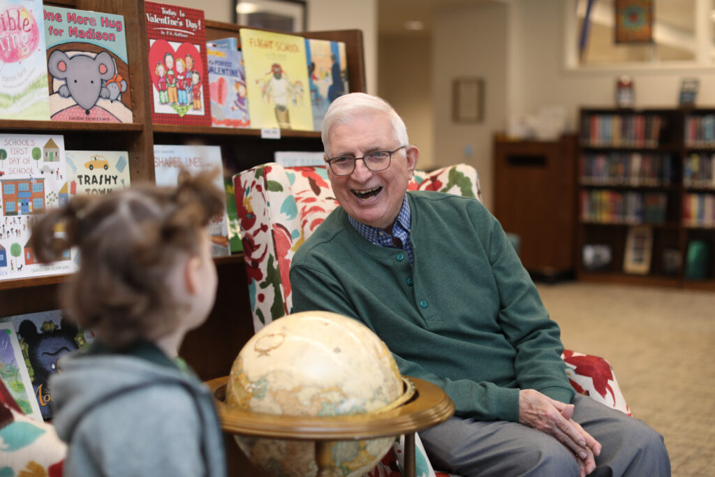 Resident interacting with children at Bayview’s Intergenerational Children’s Center in Seattle, showing the everyday connections that take place within a progressive senior living community.