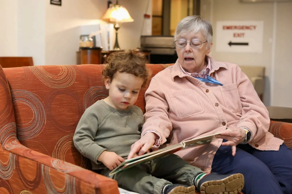 A resident reads with a child at Bayview’s Intergenerational Children’s Center, connecting generations at an active senior living community in Seattle.